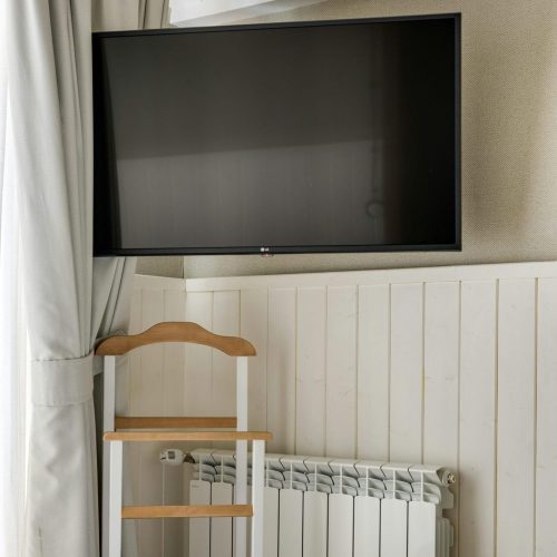 Cozy hotel room featuring a television and freshly folded towels on the bed.